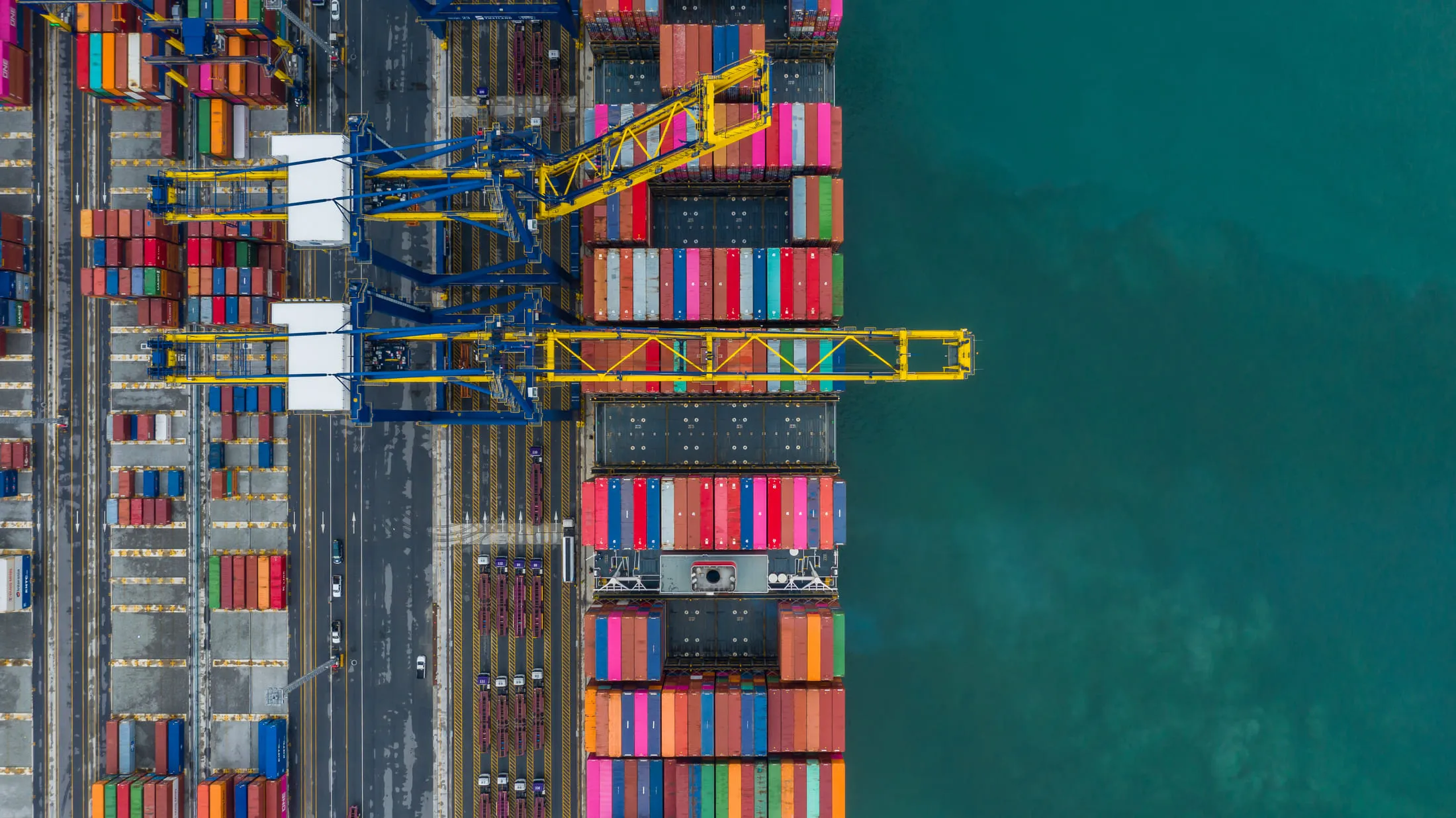 Vista aérea de una terminal portuaria de contenedores con buque en operación